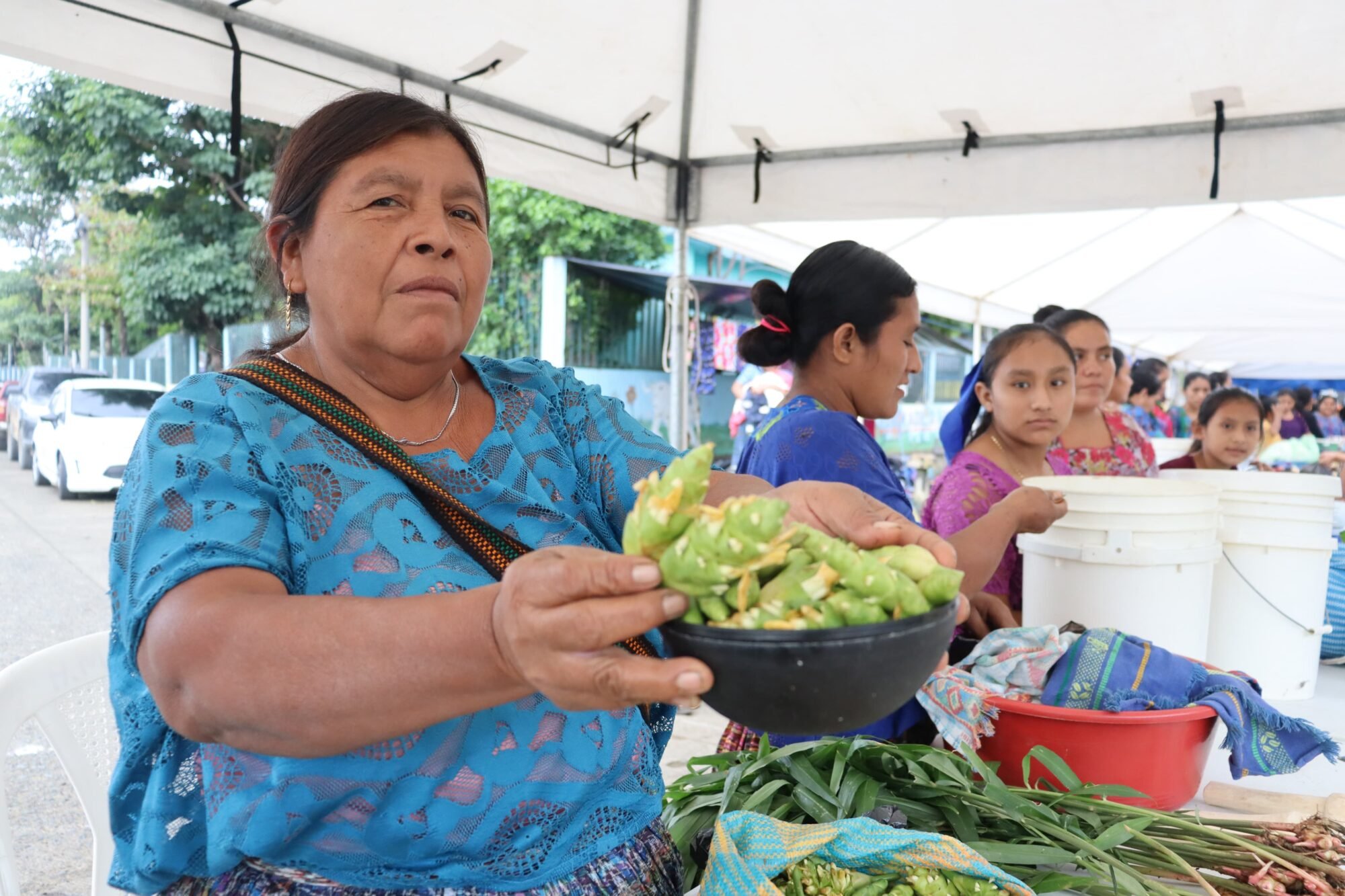  Una vendedora muestra los productos que ofrecen en el mercado comunitario. Foto de Juan Bautista Xol 