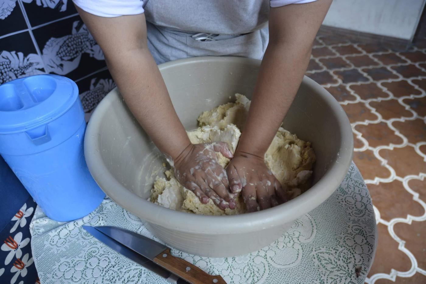 Una persona prepara la masa de maíz para hacer los tamalitos en hoja de milpa. Foto: María España. 