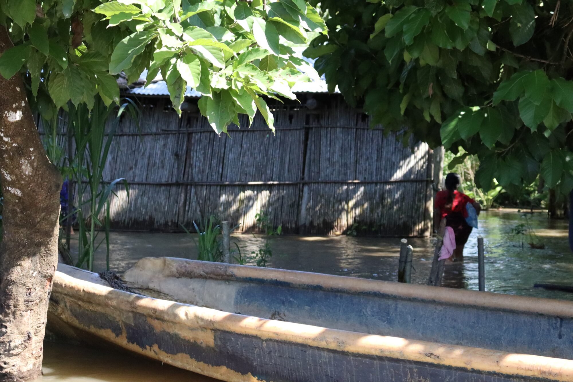  Una mujer camina en el agua para llegar a su casa. 