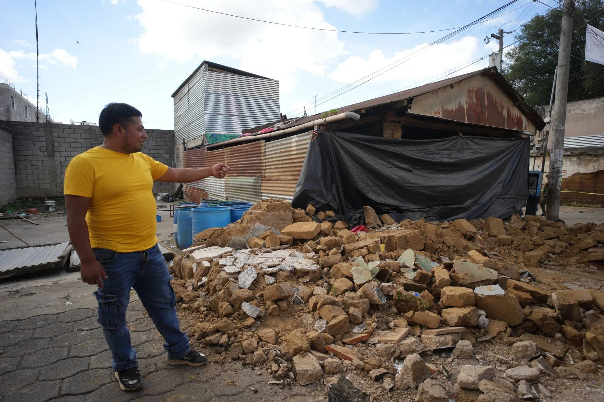  Marvin Vásquez muestra los escombros apilados al frente de su casa que ya no podrá habitar. Foto Eddy Zeta 