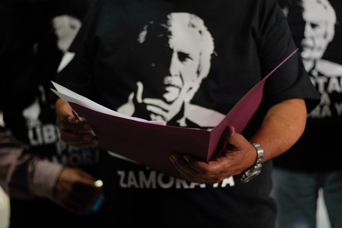 Una mujer sosteniendo una pancarta con el rostro de José Rubén Zamora